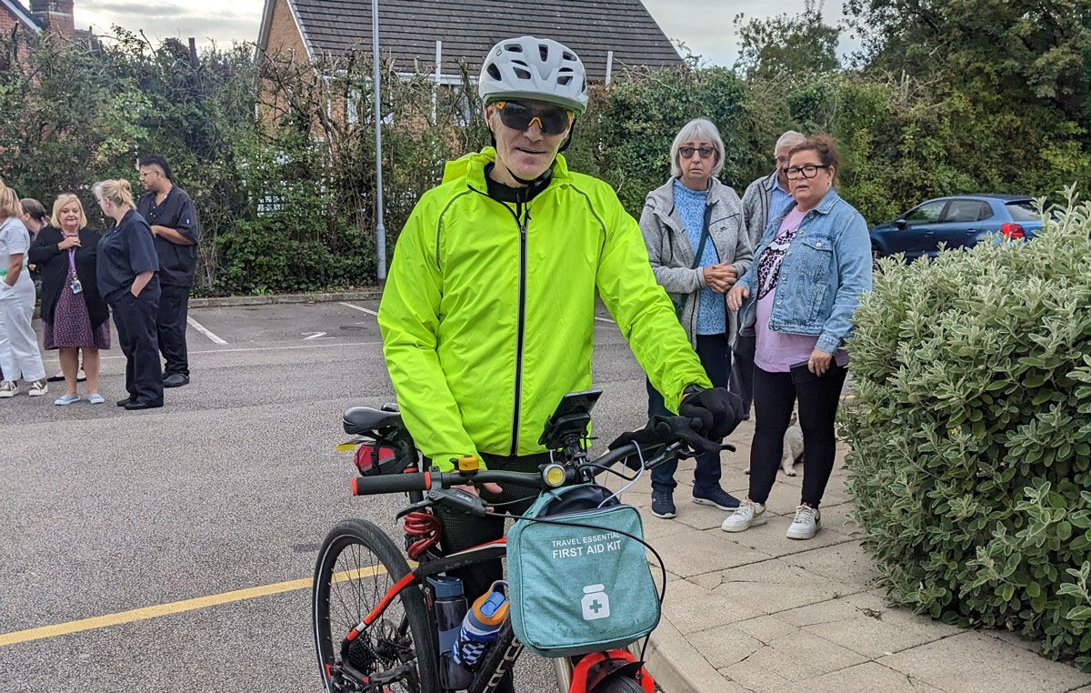 A man in a red bike with a fluorescent rain jacket